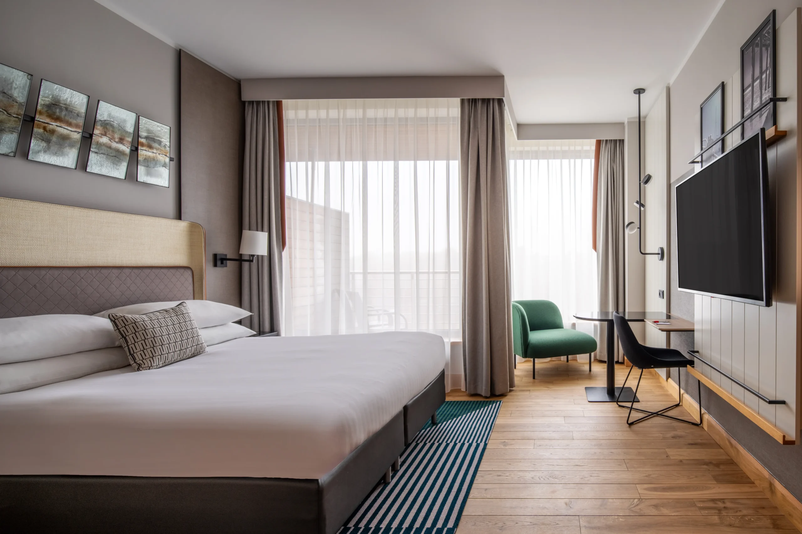 Fit-out wnętrza hotelowego pokoju z łóżkiem, stolikiem, fotelem, biurkiem i telewizorem