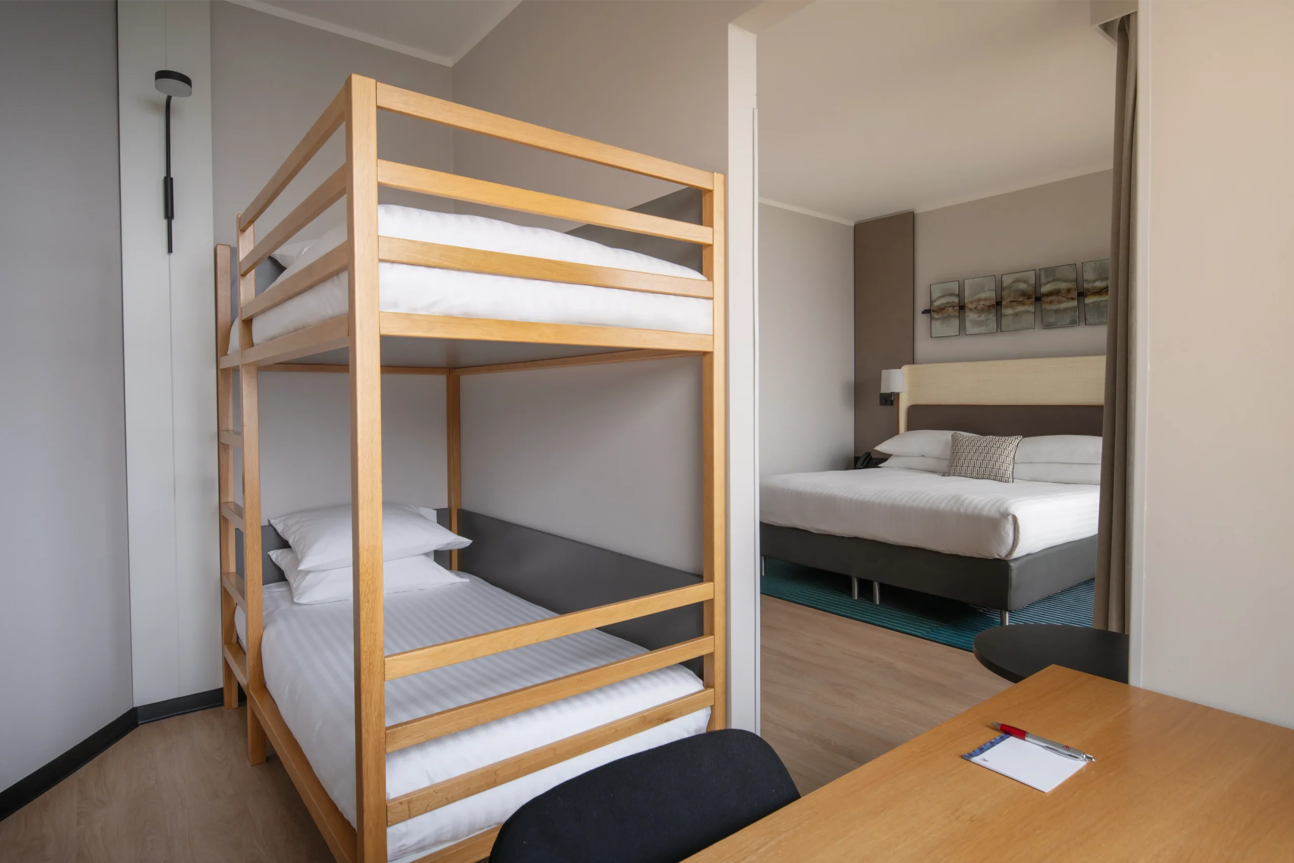 Hotelowy pokój z drewnianymi łóżkami piętrowymi i łóżkiem małżeńskim, wykończenie wnętrz