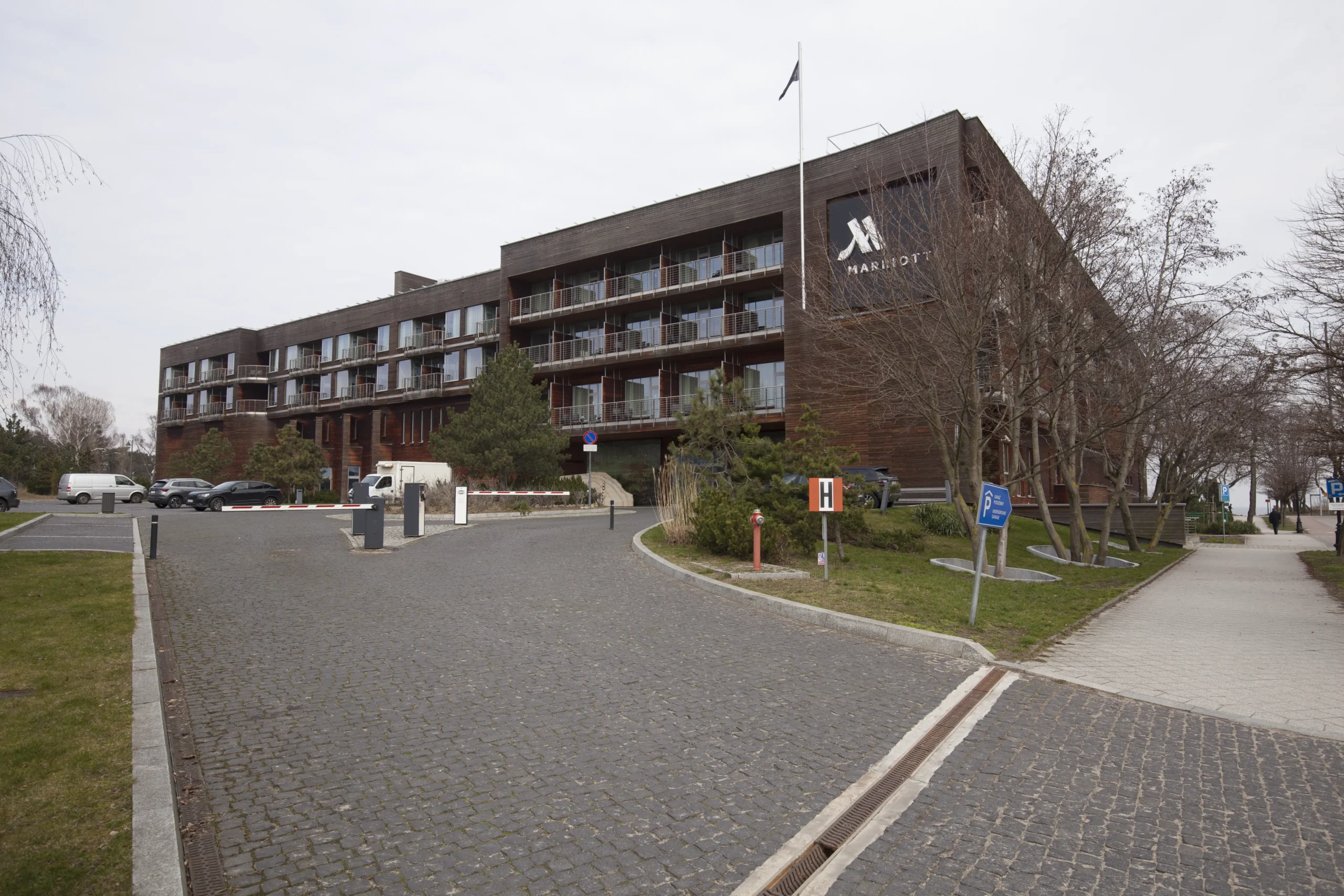 Widok na hotel z drewnianą elewacją, balkonami i brukowanym podjazdem Budowa hoteli i restauracji