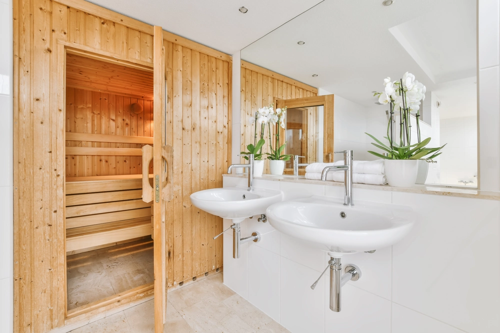 Elegancka łazienka z drewnianą sauną i dwiema umywalkami – wykończenie łazienek i stref spa