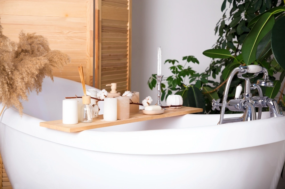 Wanna wolnostojąca z drewnianą półką na świece i akcesoria spa w eleganckim wnętrzu – Wykończenie łazienek i stref spa