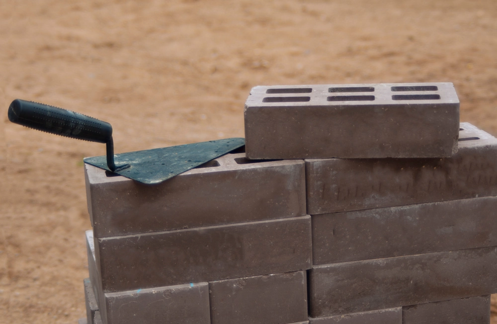 Stos pustaków betonowych z kielnią do murowania