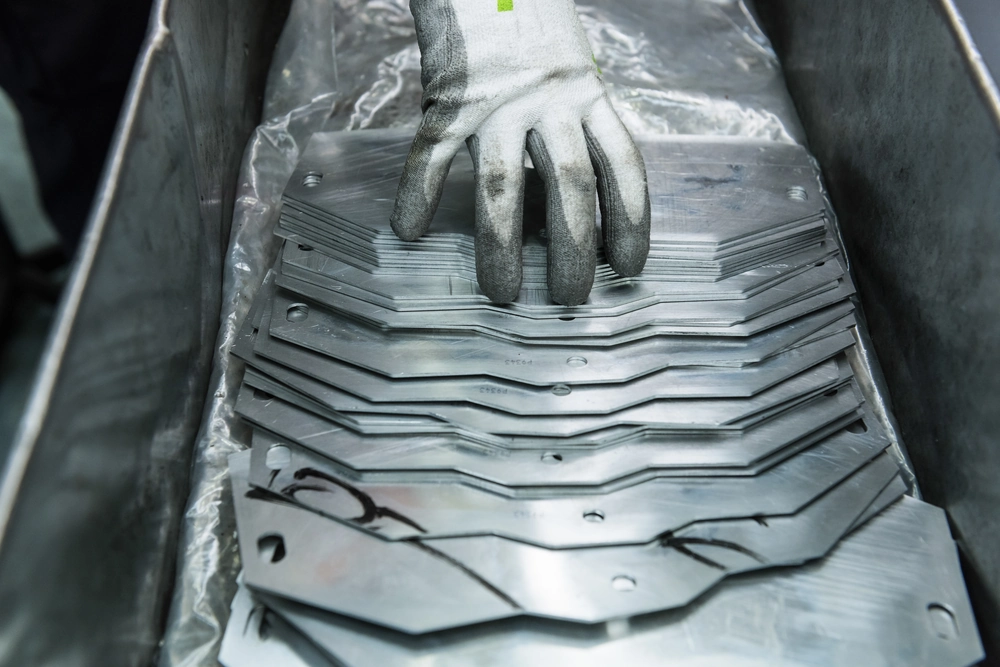 Stolarka aluminiowa – rękawica robocza nakłada części z blachy aluminiowej w stosie