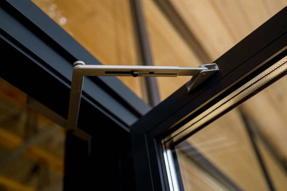 Mechanizm otwierania aluminiowego okna w czarnych ramach usługa Okna