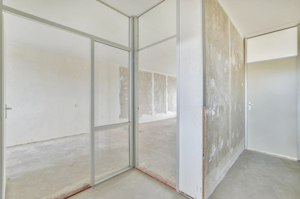 Szklane ścianki działowe w surowym wnętrzu biura