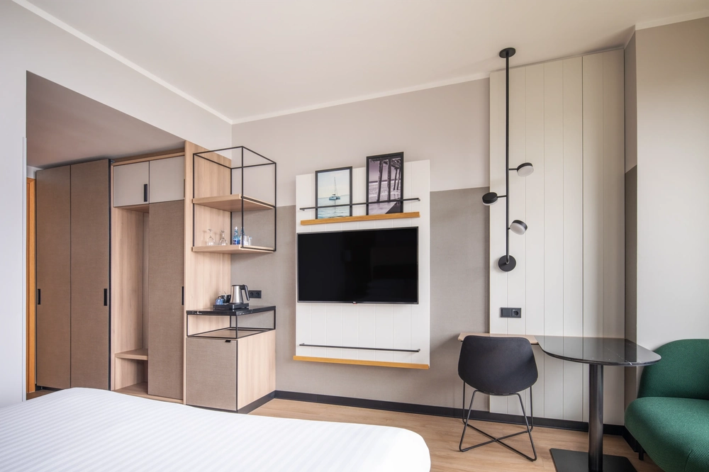 Nowoczesny pokój hotelowy z elegancką zabudową, telewizorem i miejscem do pracy – Budowa hoteli i restauracji